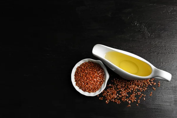 Lněná semena s olejem na dřevěný stůl — Stock fotografie