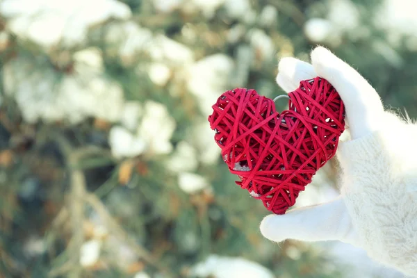 Mujer mano en manopla sosteniendo el corazón — Foto de Stock