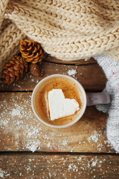 Šálek kávy s marshmallow na dřevěném stole — Stock fotografie