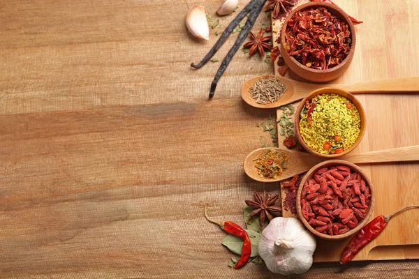 Diverse specerijen op houten tafel, bovenaanzicht — Stockfoto