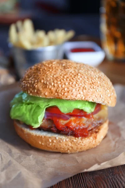 La hamburguesa grande sabrosa sobre el papel, cierran —  Fotos de Stock