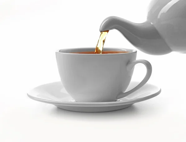 一杯の紅茶とティーポット、白で隔離 — ストック写真