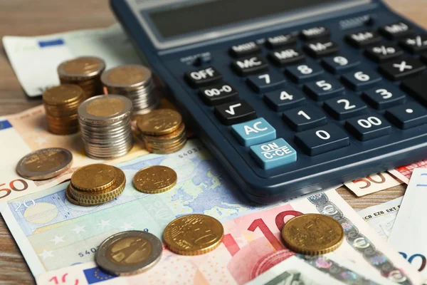 Calculator with banknotes and coins — Stock Photo, Image