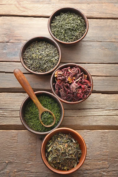 Teevielfalt in runden Schalen mit Löffel auf Holztisch, Ansicht von oben — Stockfoto