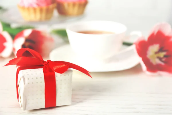 新鮮なチューリップと木製のテーブルのクローズ アップにお茶を一杯プレゼント ボックス — ストック写真