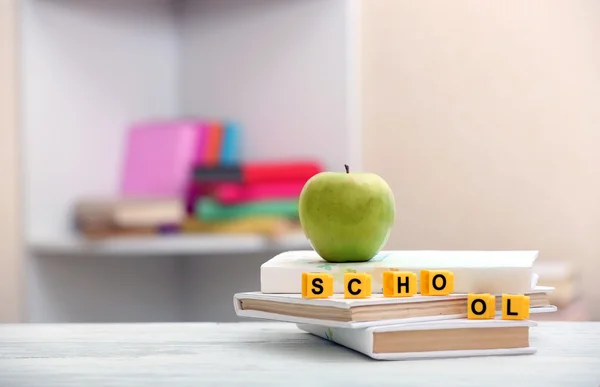 Bücher, Würfel und Apfel auf dem Tisch — Stockfoto