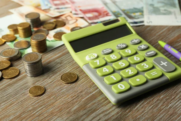 Kalkulačka s bankovky a mince — Stock fotografie