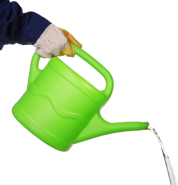 Hand pouring from green plastic watering can, isolated on white — Stock Photo, Image