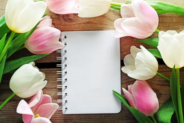 White and pink tulips with clean notebook on wooden background — Stock Photo, Image