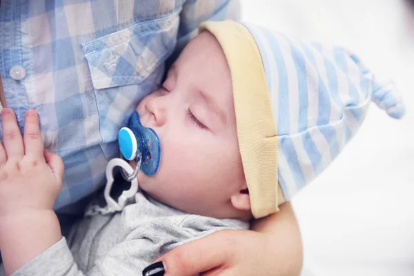 Baby with dummy sleeping in mother's hands — Stock Photo, Image