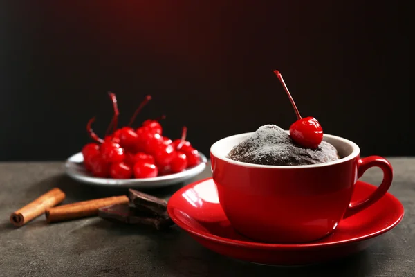 Bolo de chocolate em uma caneca vermelha com uma cereja em cima, close-up — Fotografia de Stock