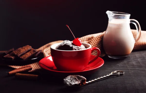 Шоколадный торт в красной кружке с вишенкой на темном фоне, закрыть — стоковое фото