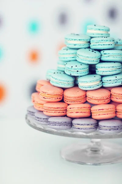 Many varicolored tasty macaroons on glass tray, close up — Stock Photo, Image