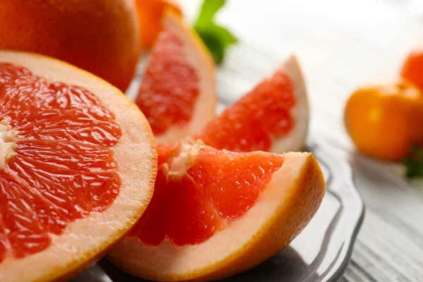 Stukken van grapefruit op houten lichte achtergrond — Stockfoto