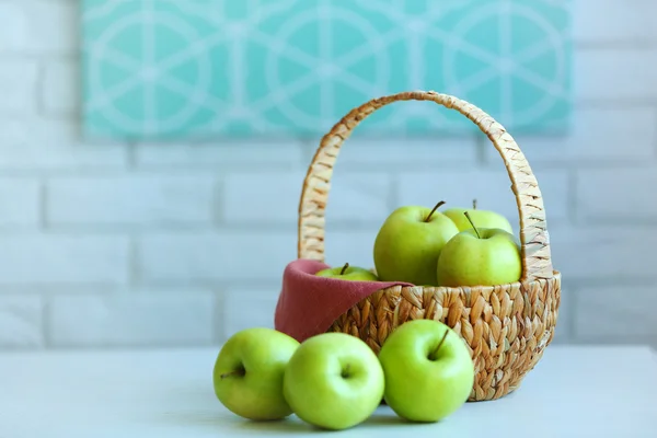 Ripe green apples in basket on a kitchen table — Stock Photo, Image