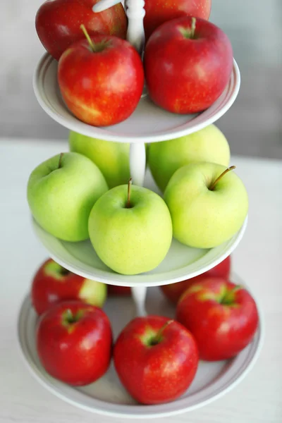 Reife rote und grüne Äpfel auf einem Ständer in der Küche — Stockfoto