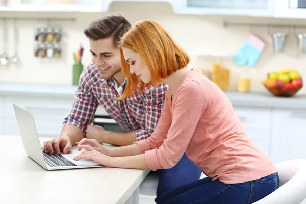 Couple using laptop on the kitchen — Stock Photo, Image