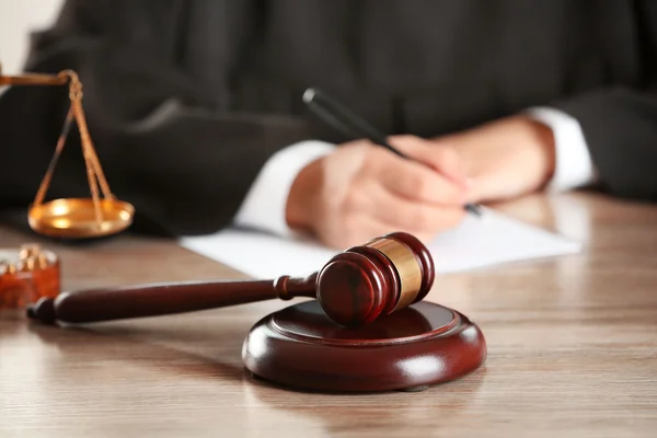 Judge writing on paper with gavel — Stock Photo, Image