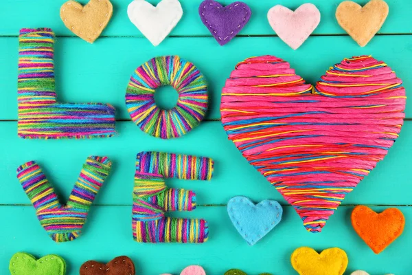 Pojęcie Walentynek. Kompozycja kolorowych serc ręcznie na turkus tło drewniane — Zdjęcie stockowe