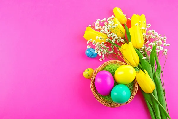 Multicoloured Easter eggs and tulips on pink background — Stock Photo, Image