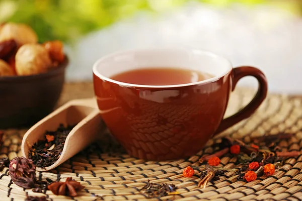 Tasse de thé et fruits secs sur fond naturel flou — Photo