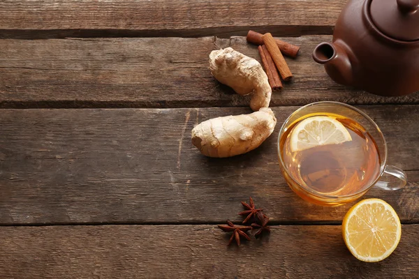 Tasse Tee mit Ingwer und Zimt auf Holzgrund — Stockfoto