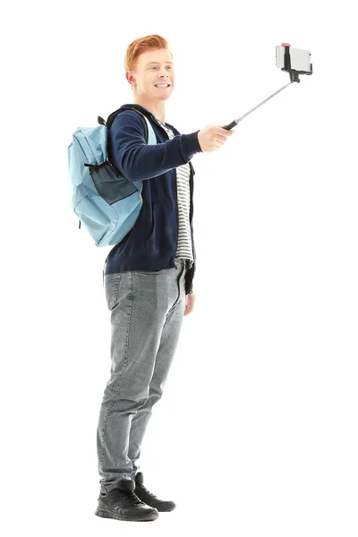 Pohledný Mladík Batohem Používající Hůl Pro Foto Jeho Izolované Bílém — Stock fotografie