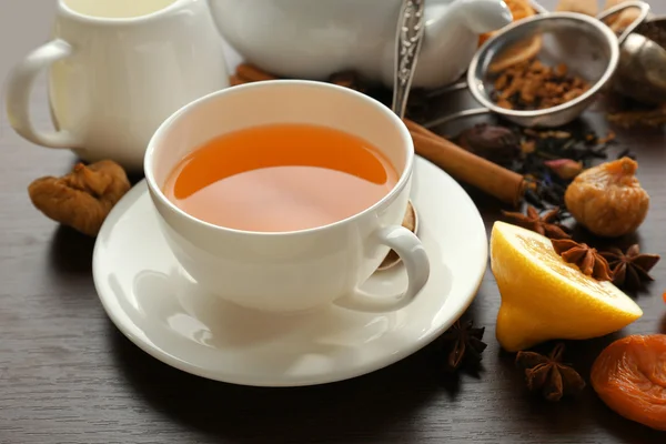 Tasse Tee und leckere Zutaten auf dem Tisch — Stockfoto