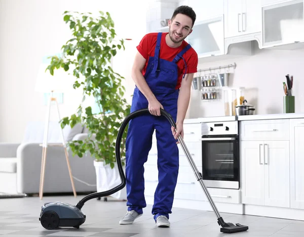 진공 청소기와 함께 아파트에서 청소 하는 남자 — 스톡 사진