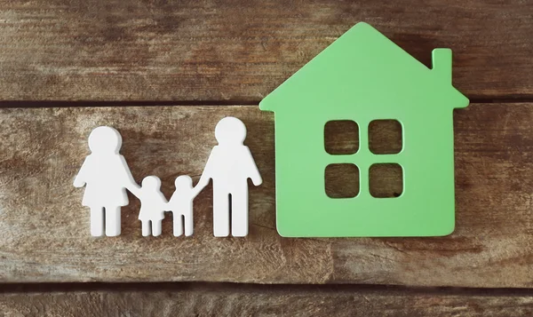 Figure de famille avec une maison sur fond en bois — Photo