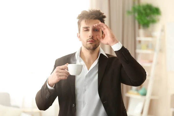 Sonolento segurando uma xícara de café . — Fotografia de Stock