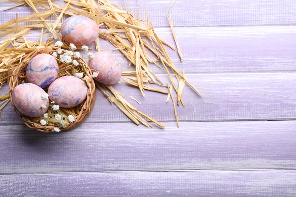 Пасхальные яйца в плетеной корзине, вид сверху — стоковое фото