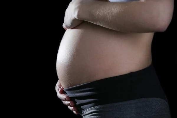 Zwangere vrouw op zwarte achtergrond — Stockfoto