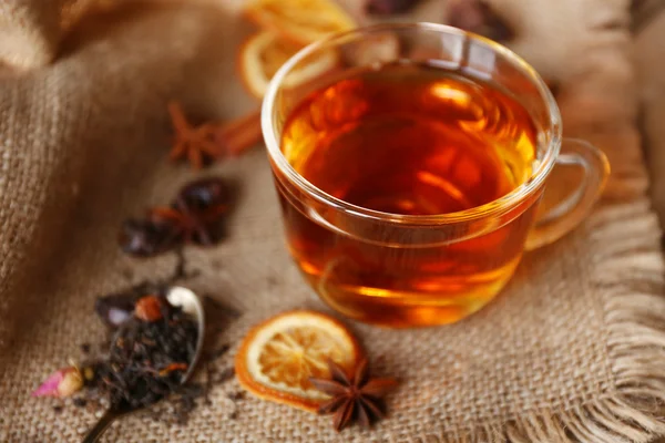 Glas Tee mit Gewürzen auf Sacktuch Nahaufnahme — Stockfoto