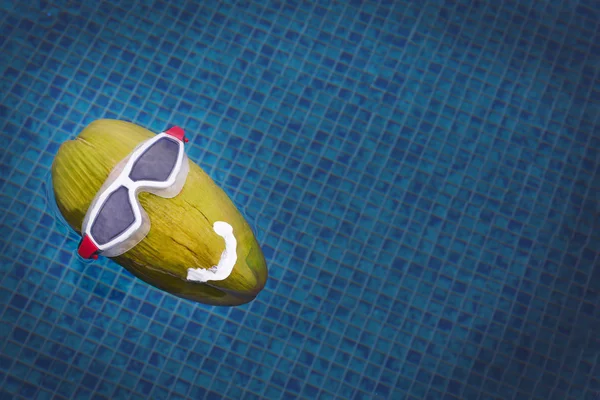 Grüne Kokosnuss schwimmt im Pool — Stockfoto