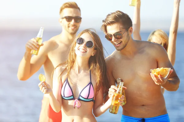Glückliche Freunde, die Bier am Strand trinken — Stockfoto