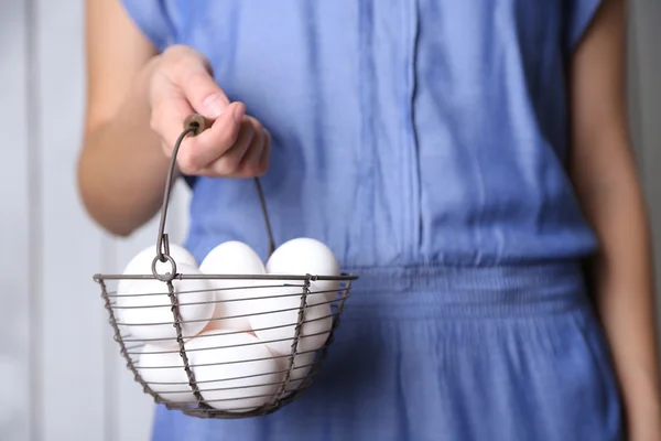 Œufs dans le panier dans les mains de la femme — Photo