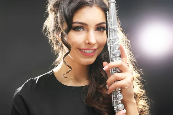 Beautiful young woman with flute on dark background — Stock Photo, Image