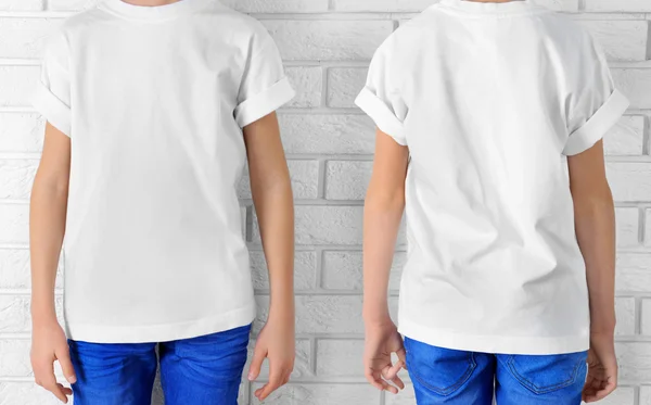 Kleding reclame. Jongen in wit T-shirt en jeans op bakstenen muur achtergrond — Stockfoto