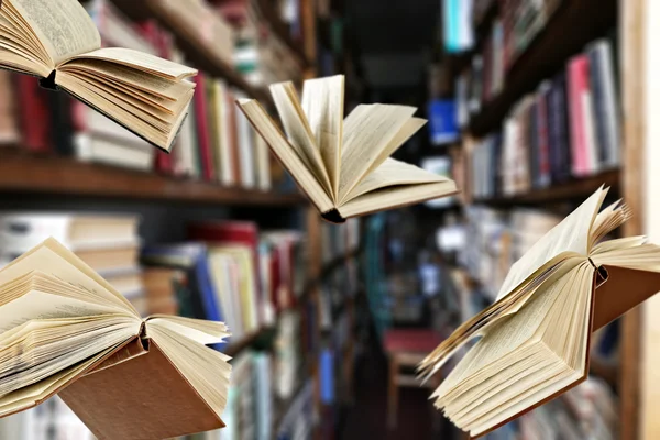 Kütüphane kitap rafı arka plan üzerinde uçan kitaplar — Stok fotoğraf