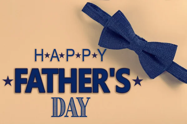 Happy Father's Day. Dark blue bow tie on beige background — Stock Photo, Image