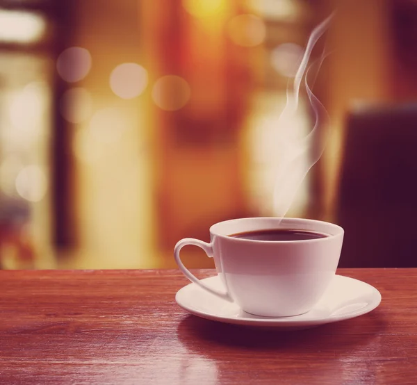 Xícara de café na mesa no fundo do café azul — Fotografia de Stock