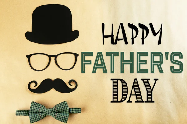 Happy Father's Day. Bowler hat, mustache and bow tie on beige background — Stock Photo, Image