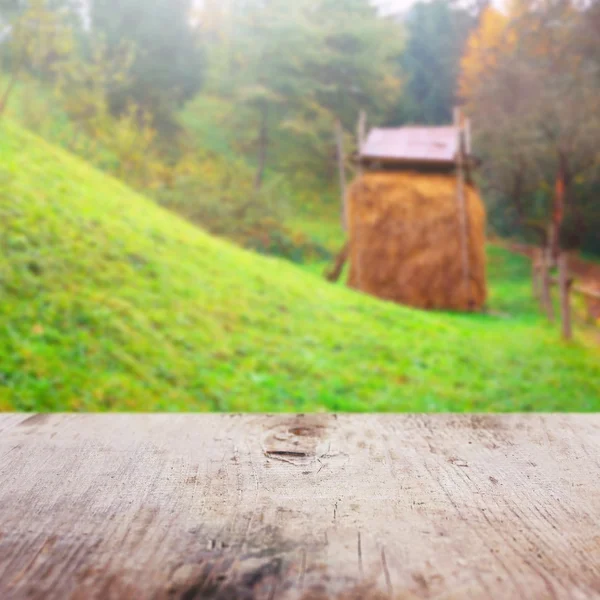 Tavolo in legno sulla natura offuscata — Foto Stock
