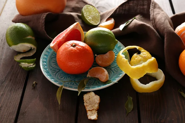 Fresh citrus fruits with green leaves on wooden table closeup — Stock Photo, Image