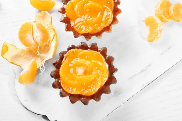 Pasteles dulces con mandarinas en la mesa, de cerca — Foto de Stock