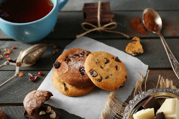 Chocolate chip cookies and a cup of tea on wooden background — Stock Photo, Image