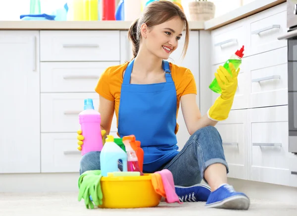 Jovem mulher sentada com fluidos de limpeza — Fotografia de Stock