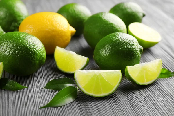 Limes and slices on wooden table, closeup — Stock Photo, Image