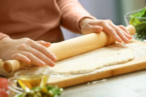 Frau rollt Pizza aus — Stockfoto